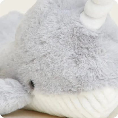 Close-up of the Warmies Narwhal showing its soft gray fur and white tusk against a light background.