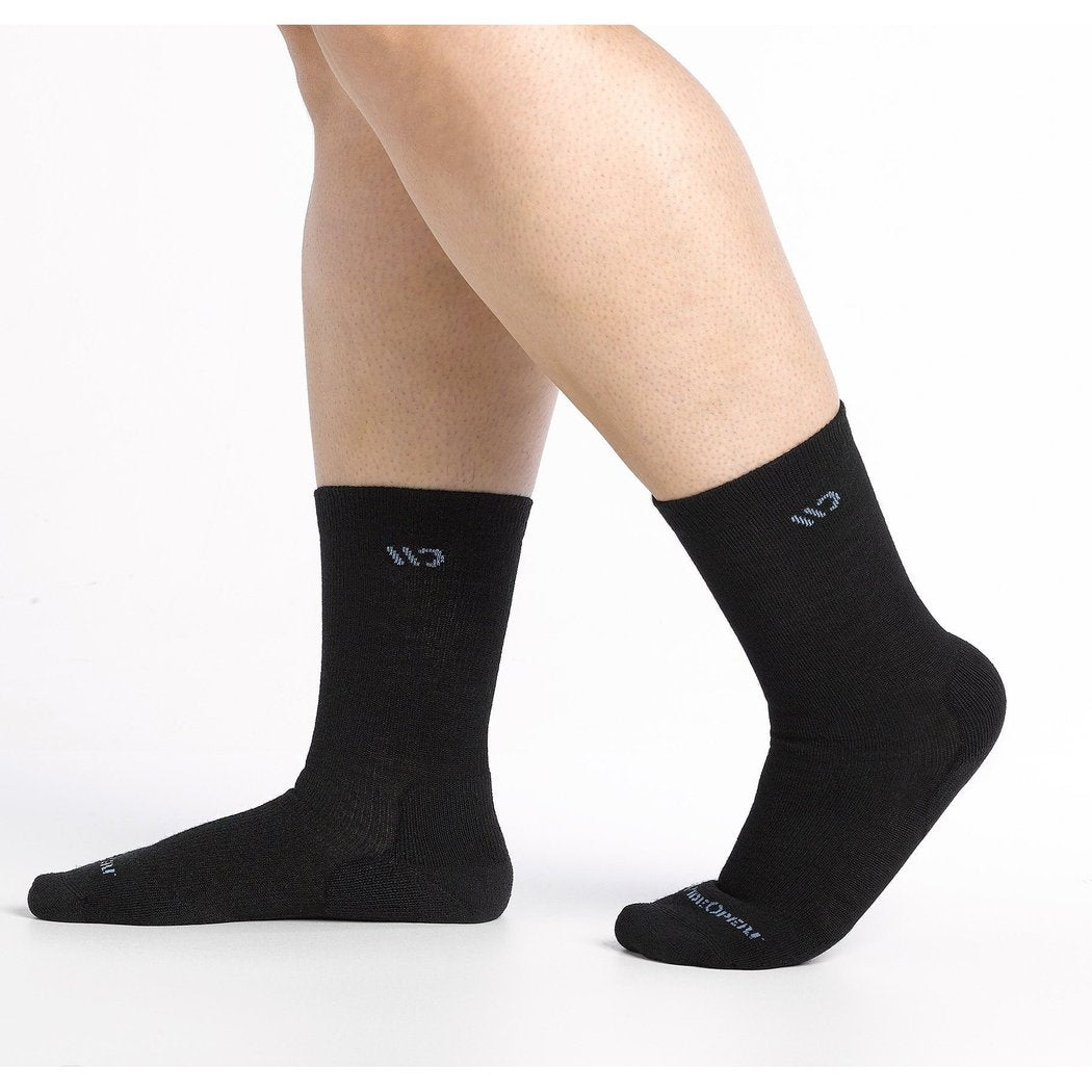 Close-up of a model wearing Wide Open Women's Solid Cushioned Crew Socks in Black against a white background.