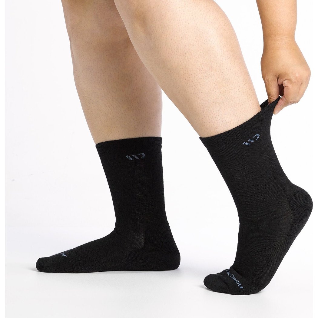 Close-up of a model wearing Wide Open Women's Solid Cushioned Crew Socks in Black with a white background.