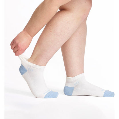 Close-up of a model wearing Wide Open Women's Solid No Cushion Ankle Socks in White with light blue heel and toe accents against a white background.